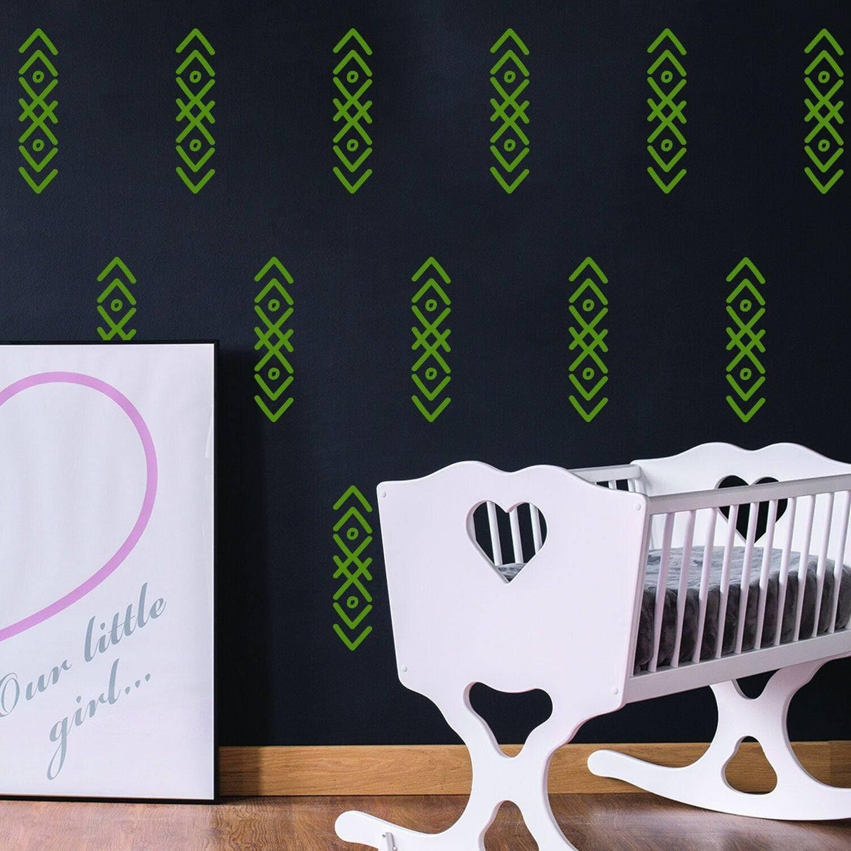 WhimsyArrows vinyl wall decals in green on black nursery wall with white crib and framed decor.