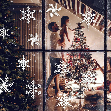 Festive family decorating a Christmas tree through a window adorned with snowflake stickers.