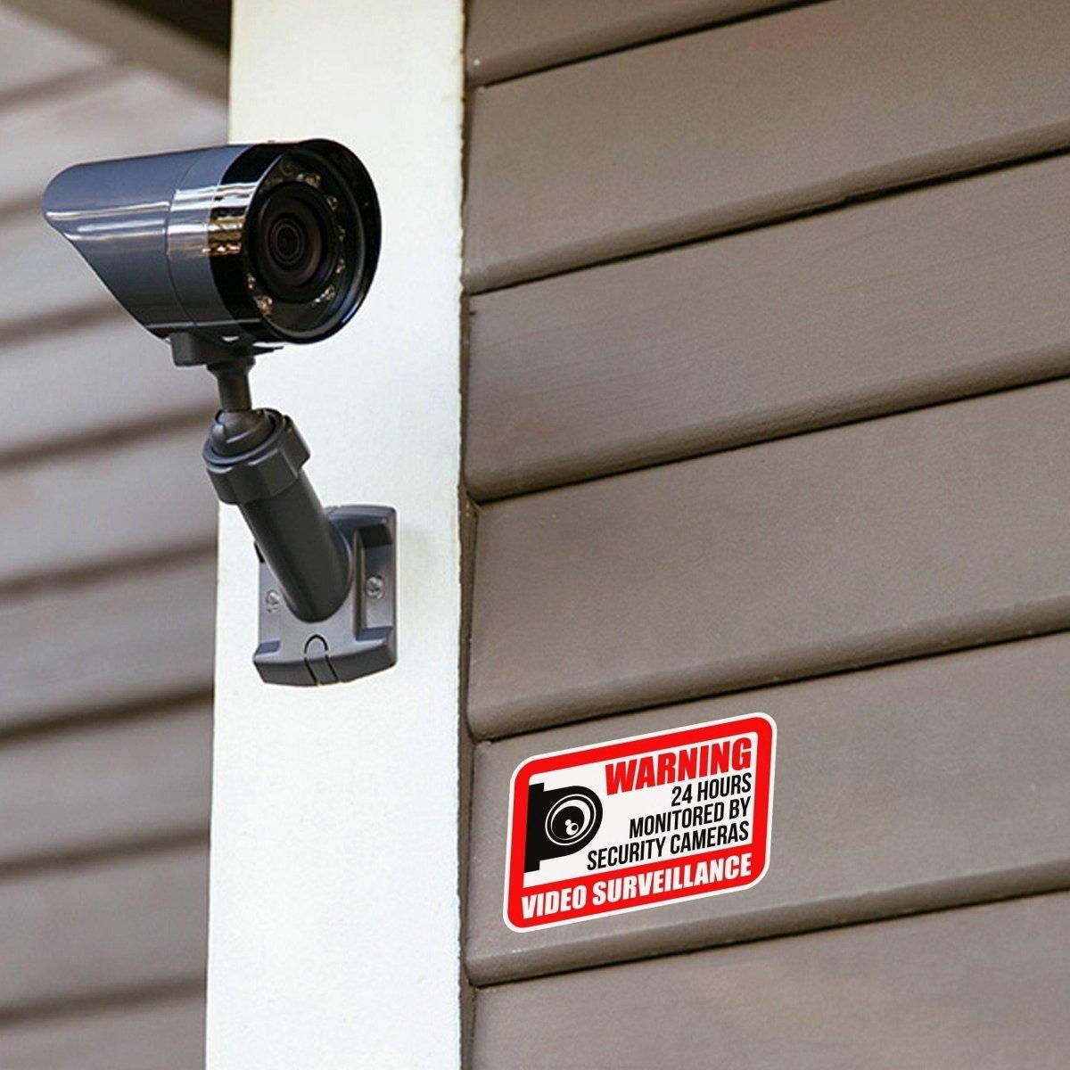 Video surveillance camera mounted on a wall with a security warning sign, enhancing home security.