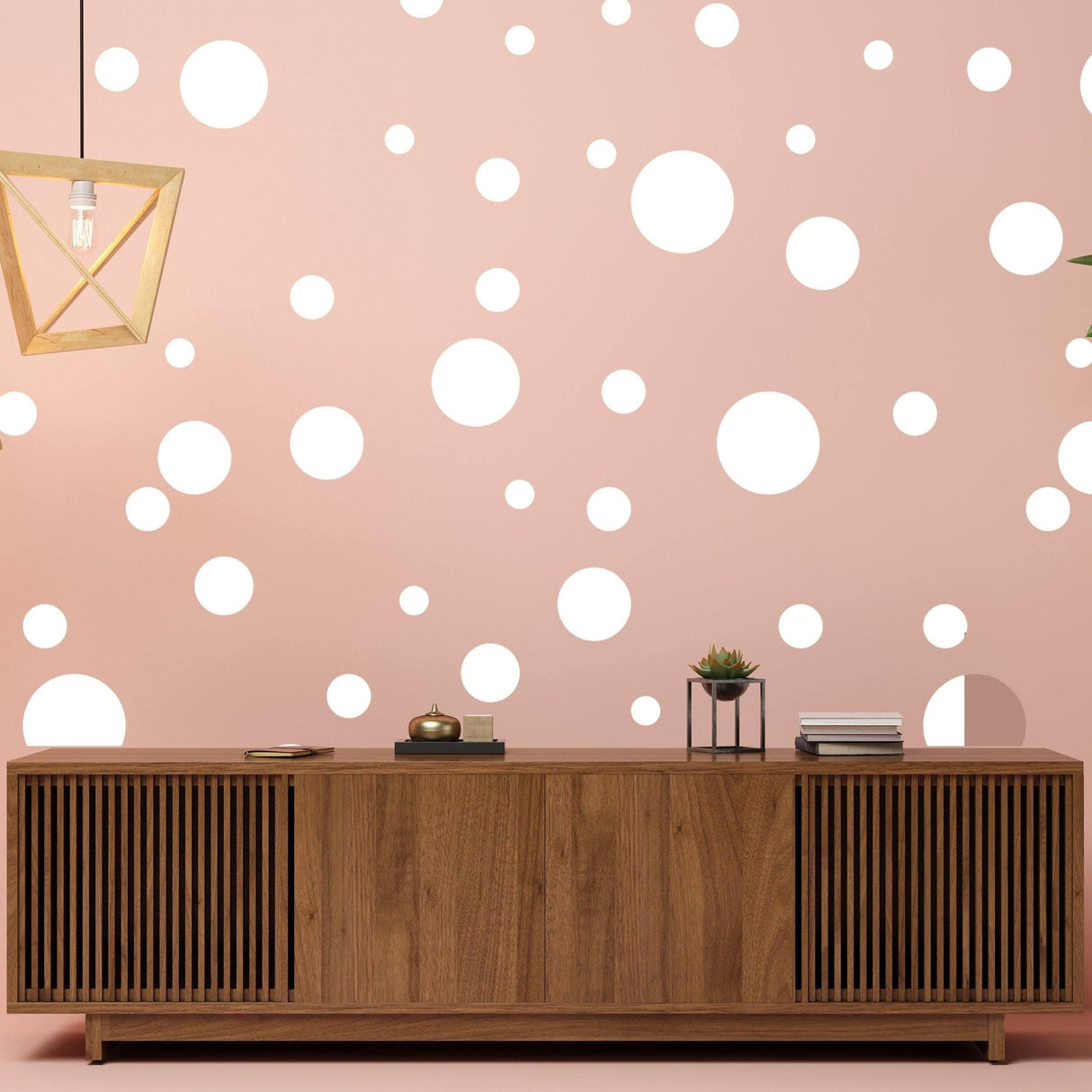 Adhesive white round dot stickers on a pink wall with wooden cabinet, adding a creative decor touch.