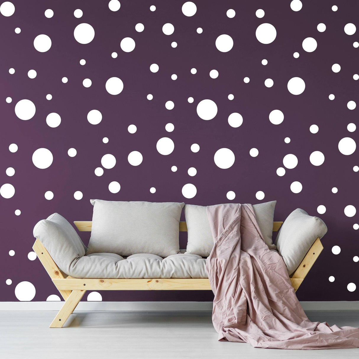 Cozy living room with a sofa and white round dot stickers on a purple wall, adding a creative touch to the decor.