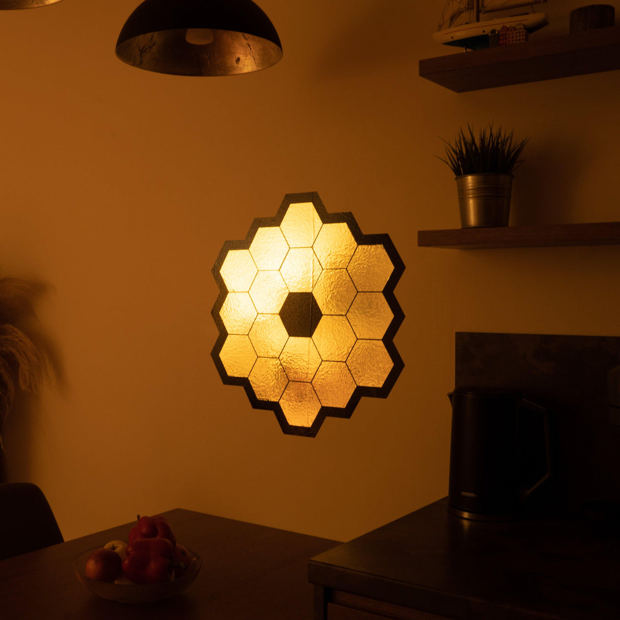 James Webb Space Telescope mirror wall sticker in gold chrome vinyl, illuminating a cozy room with its shimmering design.