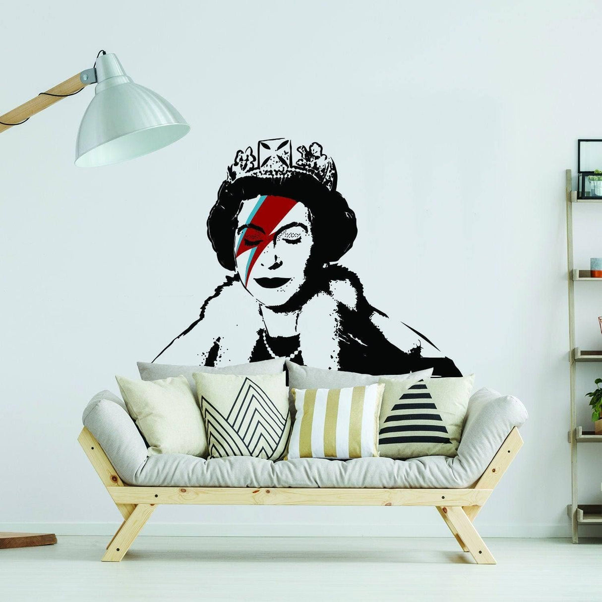 Regal Vinyl Sticker featuring Banksy-inspired design of Queen with David Bowie makeup on a white wall above a modern couch.
