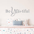 Motivational wall decal "Be YOU tiful" above a colorful polka dot bedspread, adding charm to any room.