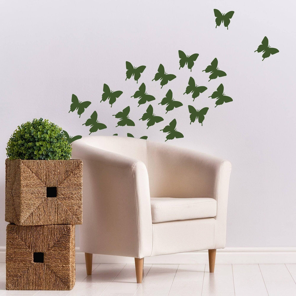 Green butterfly wall decals flying above a white armchair, creating a whimsical decor in a cozy living space.