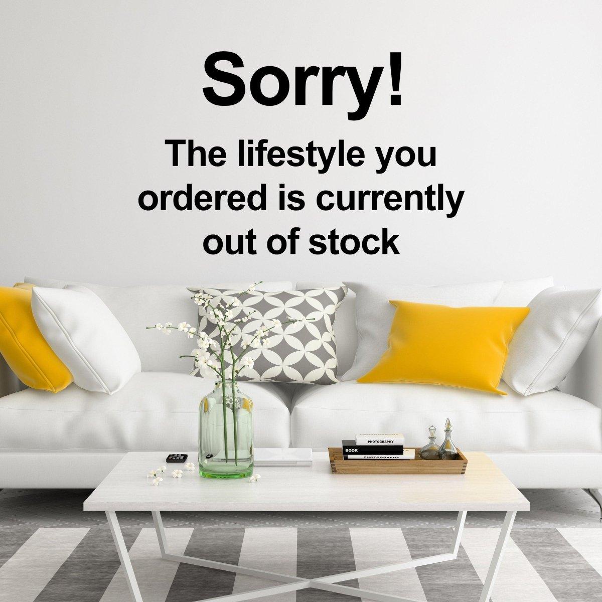 Vinyl wall decal featuring 'Sorry! The lifestyle you ordered is currently out of stock' above a stylish living room couch.