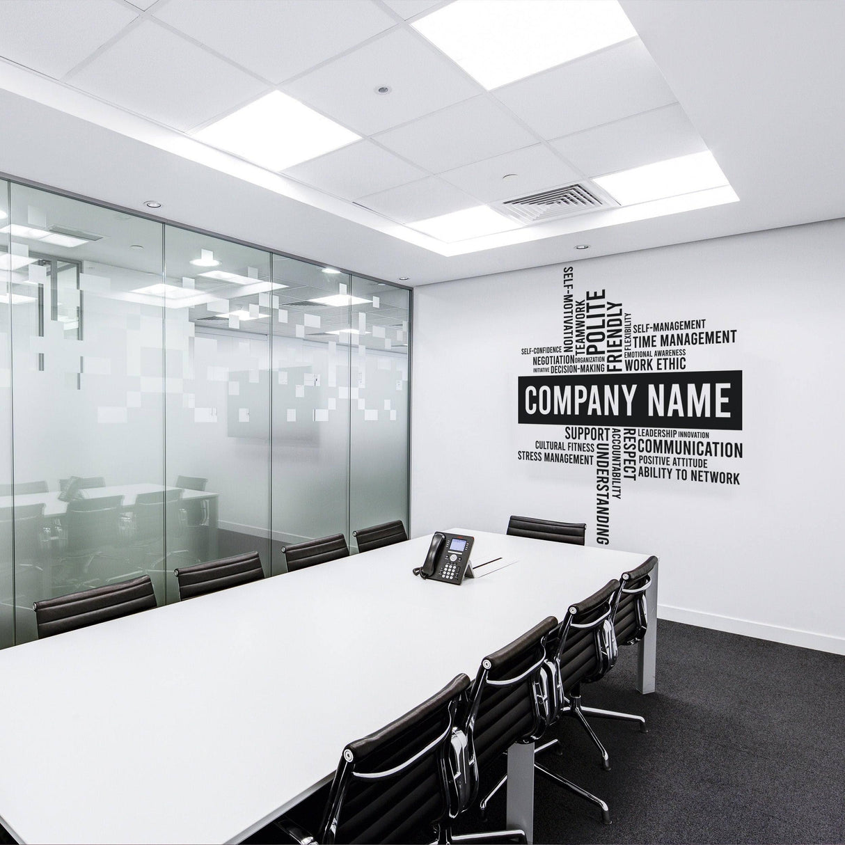 Modern office conference room featuring a personalized company name wall decal and sleek, minimalist furniture.