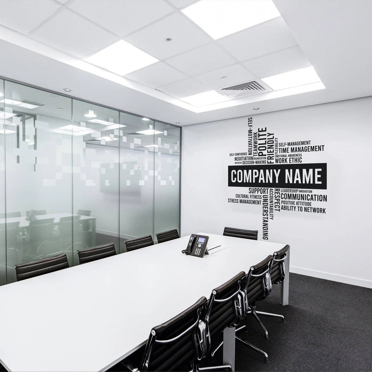 Modern office conference room featuring a personalized wall decal with 'Company Name' and motivational keywords.