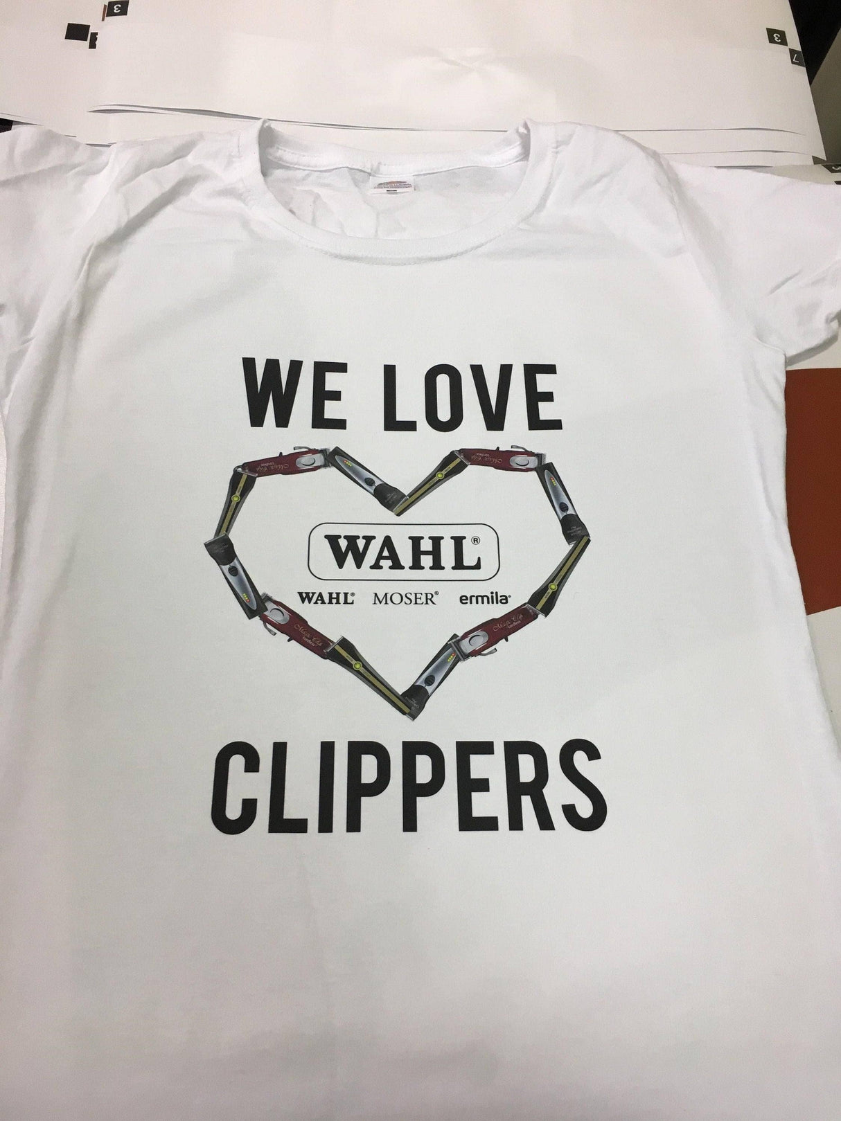 White t-shirt with the text 'WE LOVE CLIPPERS' and a heart made of hair clippers.