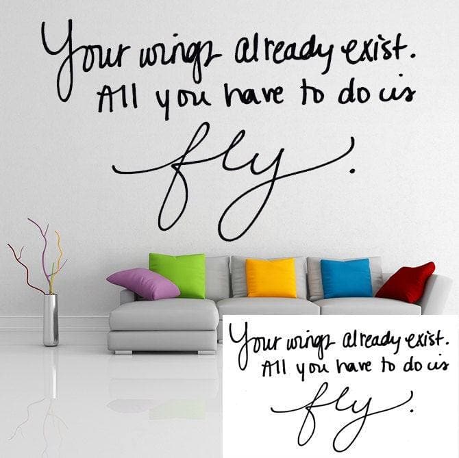 Personalized wall decal with inspiring quote 'Your wings already exist. All you have to do is fly.' near a colorful couch.