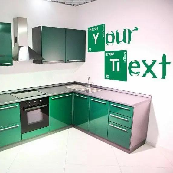 Custom text vinyl decal in modern green kitchen interior with personalized wall design.