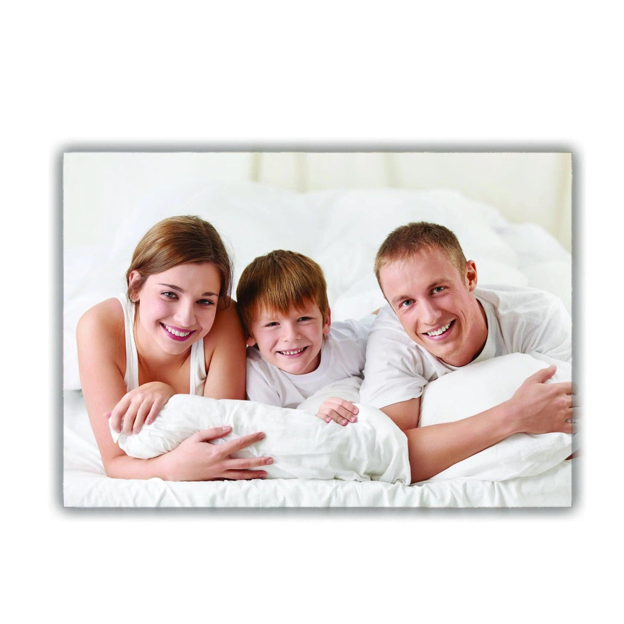 Family of three smiling and relaxing on a bed with white pillows, capturing a joyful moment on canvas.
