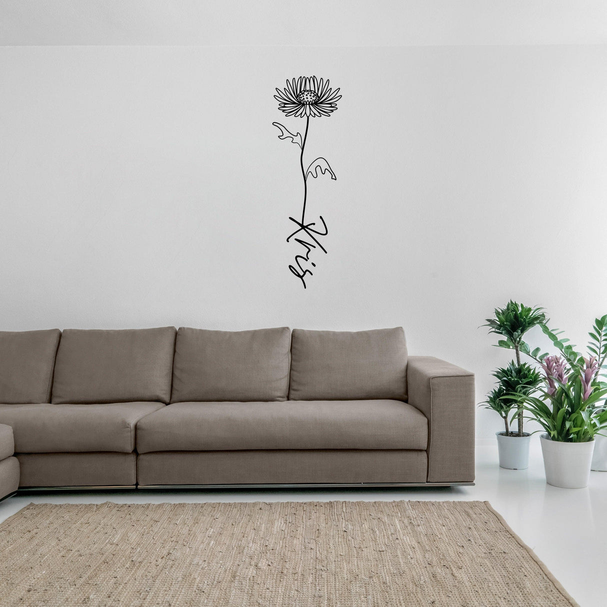 Personalized birth flower vinyl wall decal above a cozy sofa in a modern living room setting.