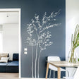 Elegant minimalist white branch wall sticker on a dark blue wall, enhancing modern living room decor.