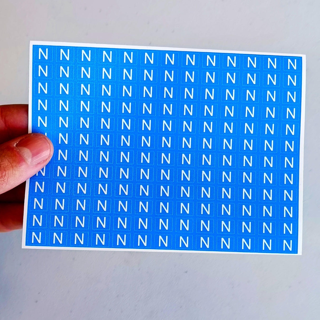 Sheet of blue neutral marking stickers featuring repeated 'N' labels for electrical safety identification.