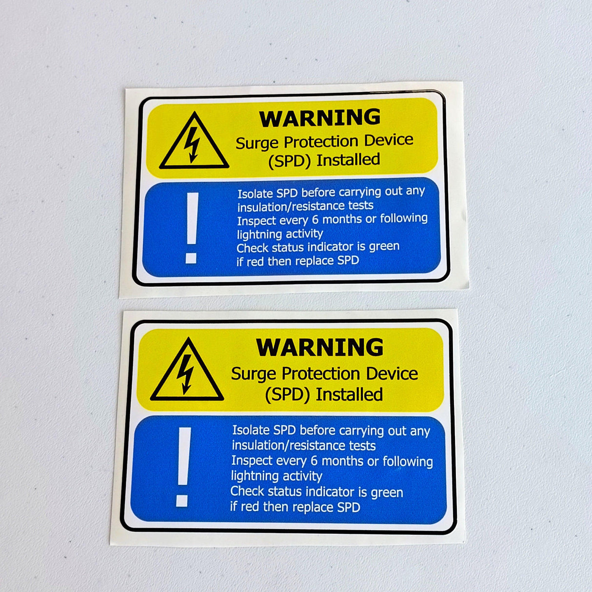 2 surge protection device (SPD) warning labels featuring safety instructions for electrical installations.