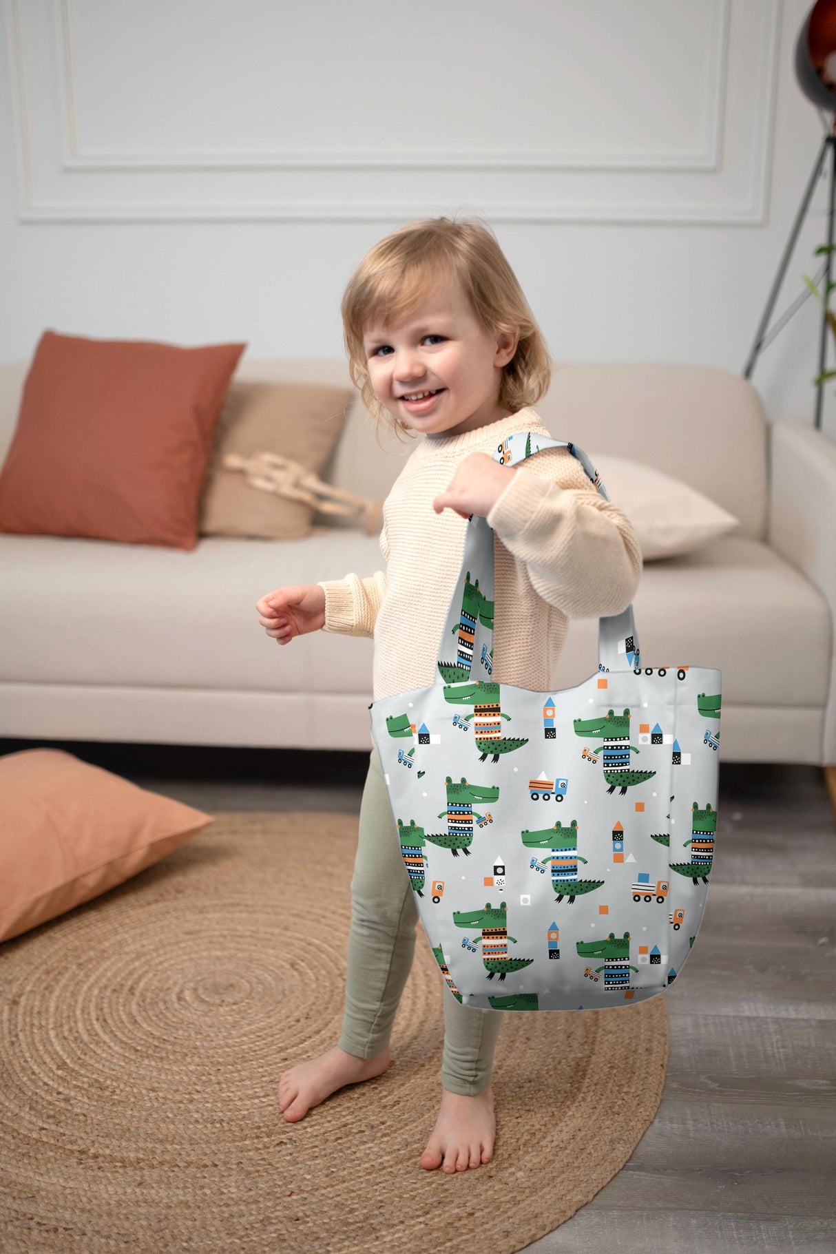 Cute child holding eco-friendly Kids Shopper Bag with dinosaur and car design, perfect for organizing small items.