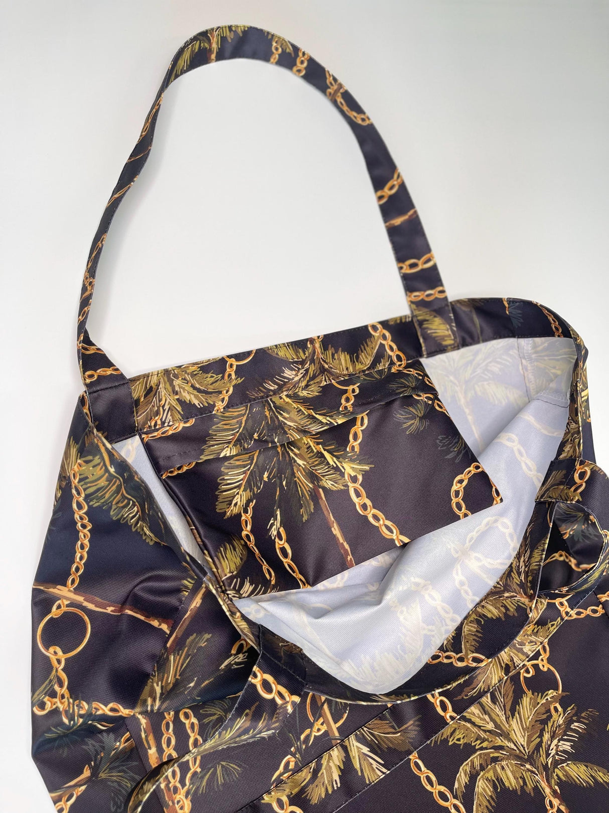 Close-up of Women's Black Shopper Bag with military brown patterns and chain design, showcasing the interior and handle.