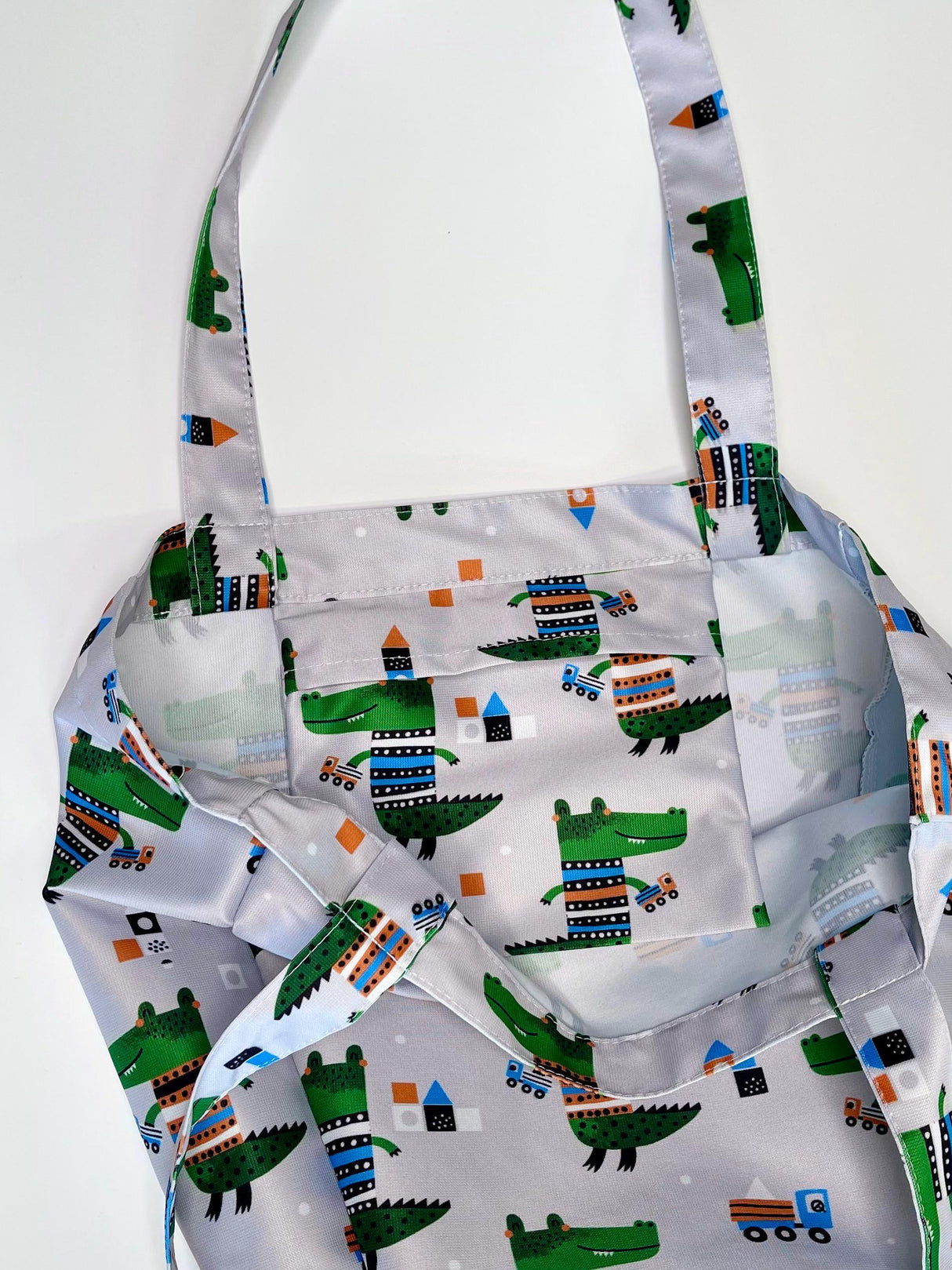 Kids shopper bag featuring playful crocodile and truck design on a grey background, perfect for little ones.