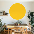 Yellow circle wall decal in a modern dining space, adding warmth and elegance to the interior design.