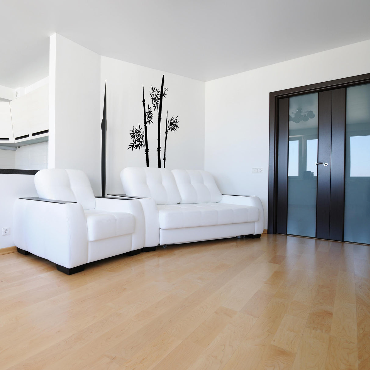 Minimalist bamboo wall decal in modern living room featuring white sofas and natural light.