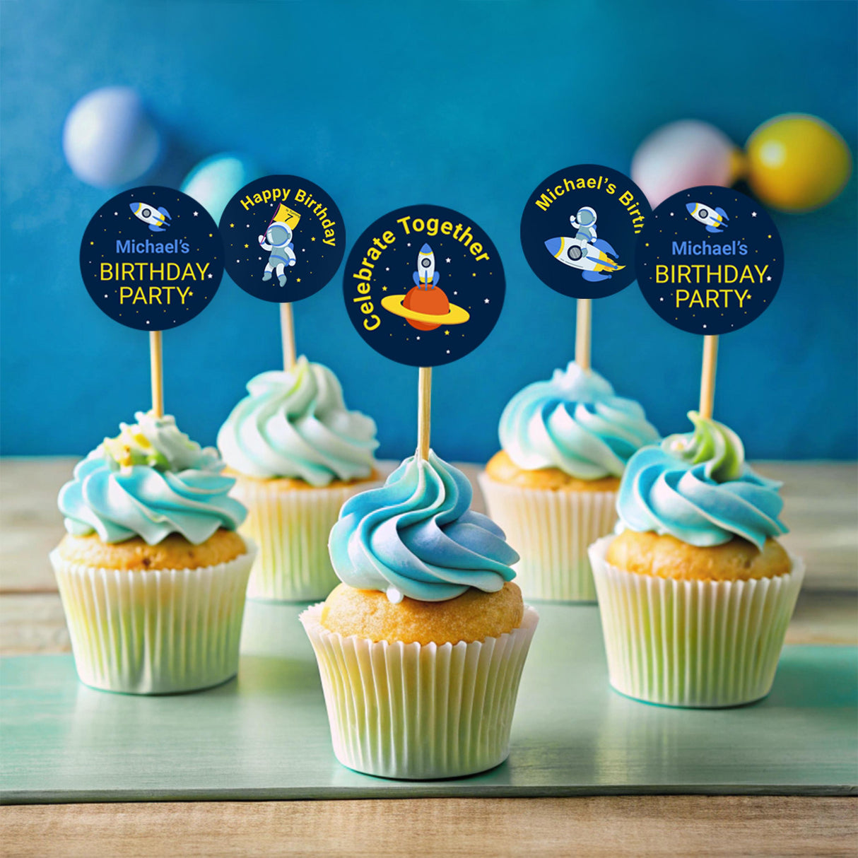 Colorful space-themed cupcake toppers for a birthday party, featuring astronaut and planet designs, personalized for Michael.