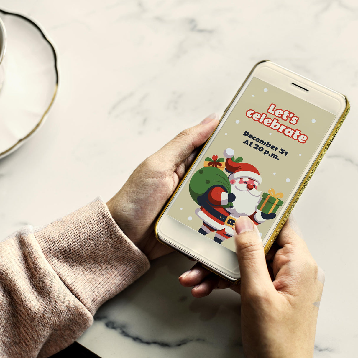 Person holding a smartphone displaying a festive Santa invitation for a Christmas celebration.