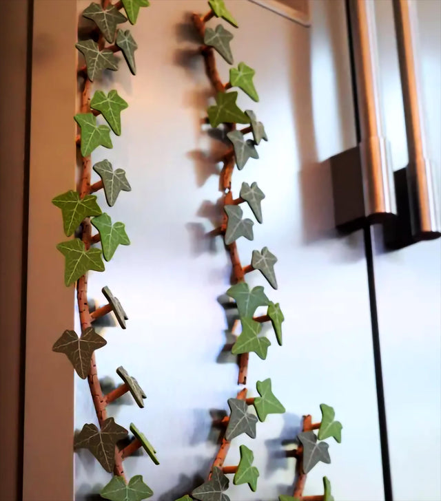 3D-printed English Ivy fridge magnet vine decorating a silver fridge.