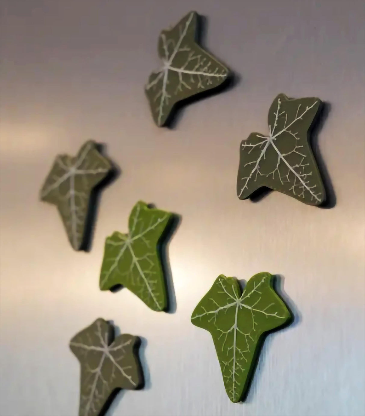 Set of green 3D printed English Ivy fridge magnets arranged on a metallic surface, adding unique decor.