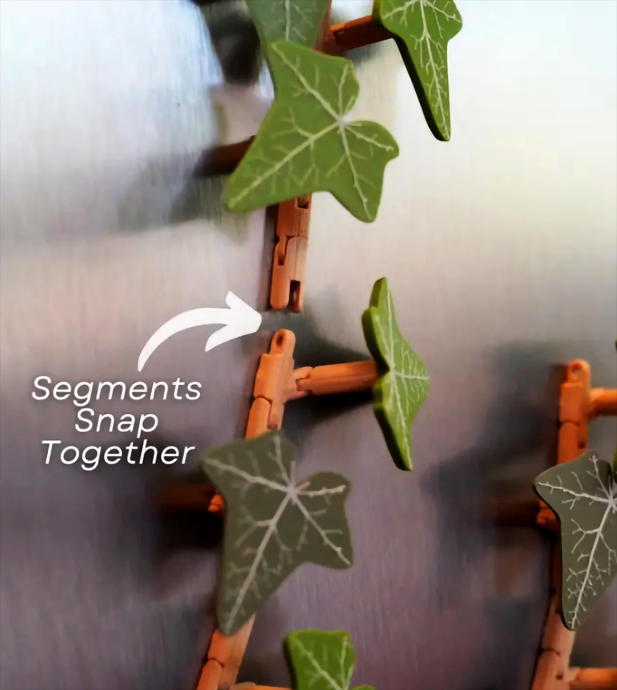 Close-up of English Ivy fridge magnet segments snapping together, showcasing articulated leaves and flexible design.