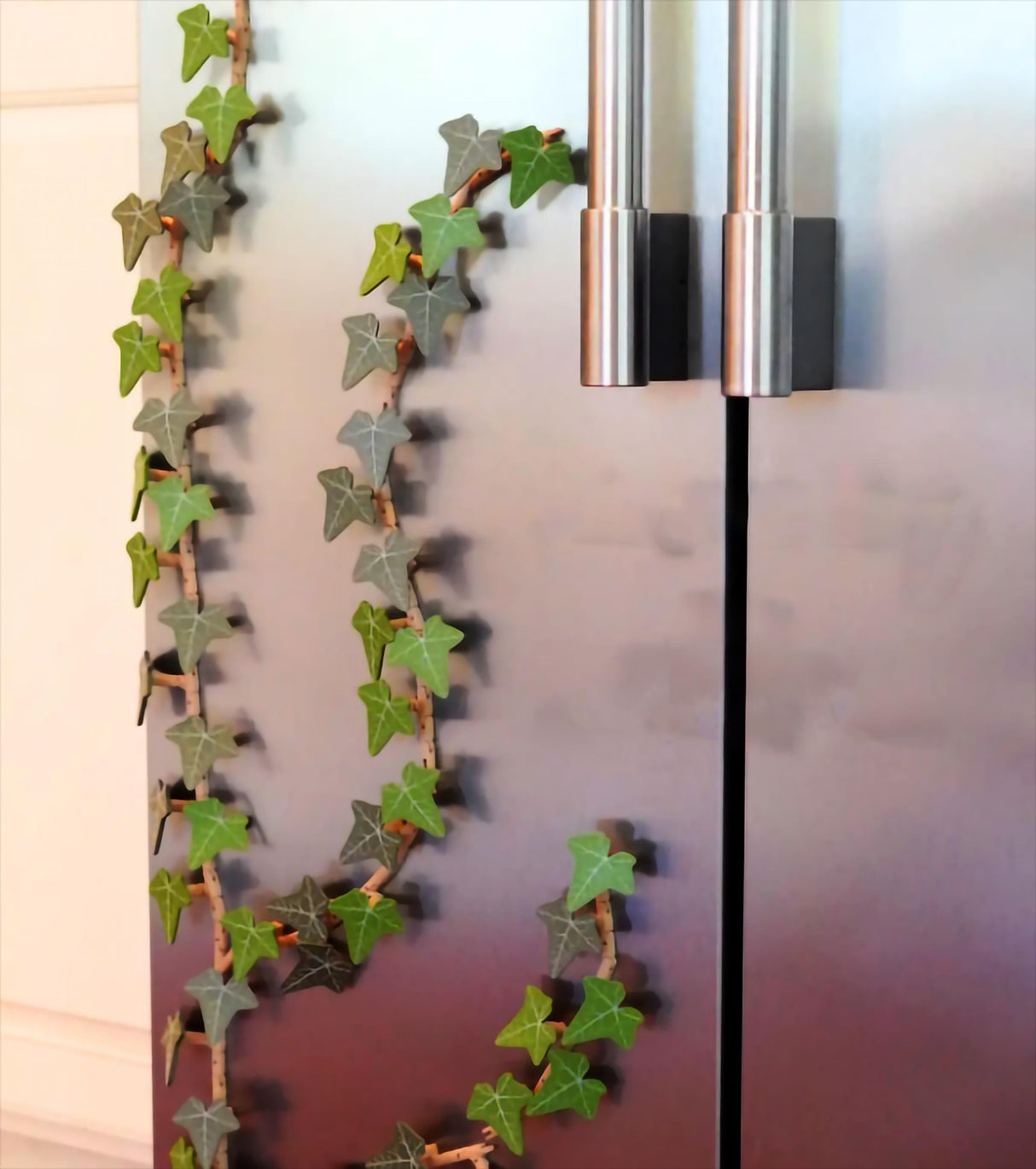 English Ivy fridge magnet vine elegantly winding up a stainless steel fridge, adding greenery and style to kitchen decor.