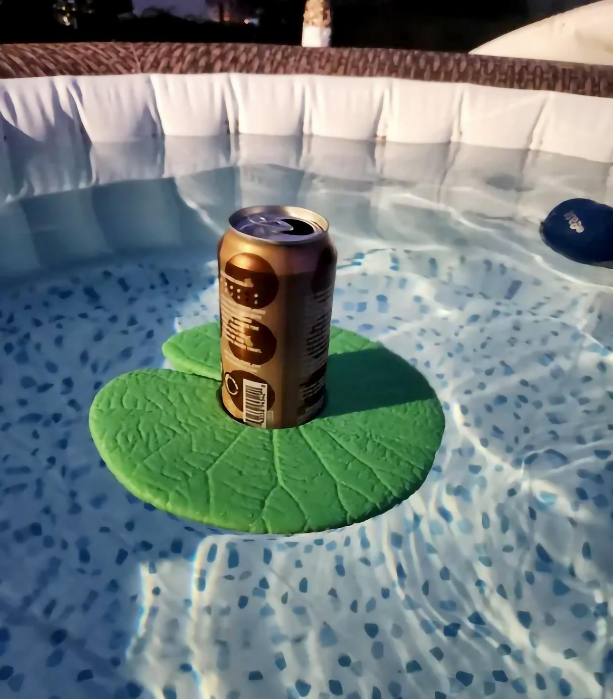 Lily Pad water cupholder floating in pool with a can, perfect accessory for drinks by the water.