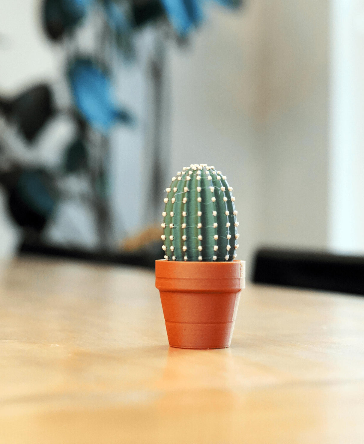 Mini clickable cactus in a terracotta pot, ideal fidget toy for desk decor and stress relief.