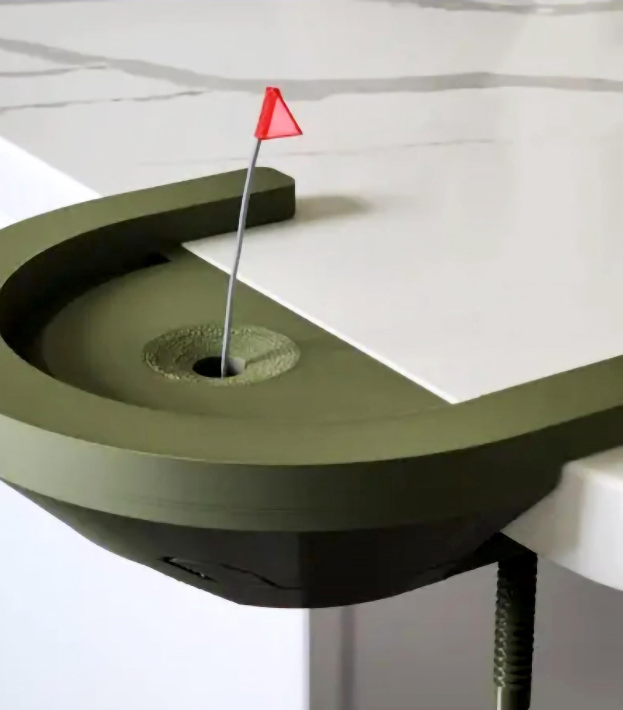 Interactive desktop golf game with a putting green and flag on a white table.