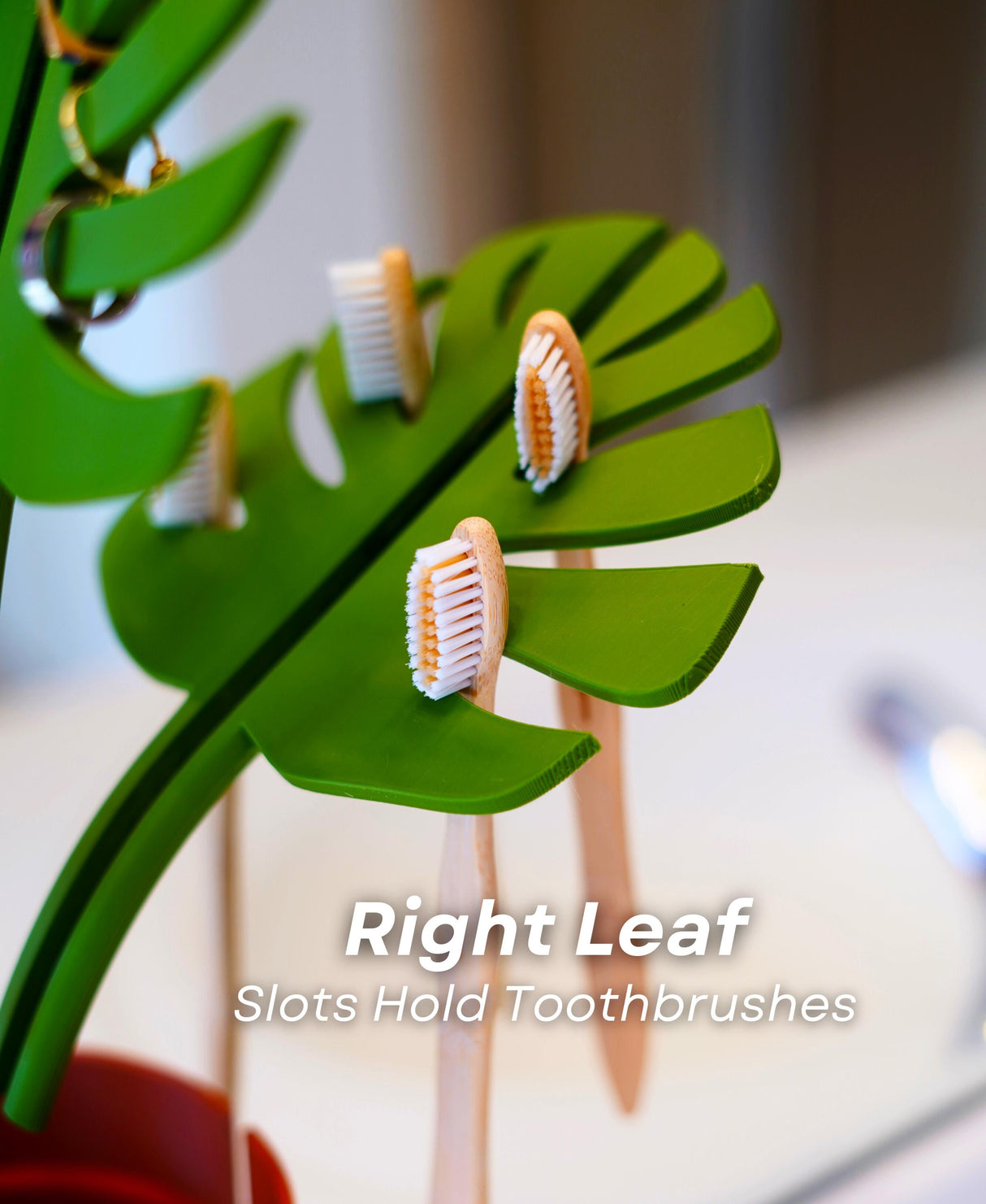 Right leaf of Mirror Monstera Organizer with slots holding toothbrushes, showcasing functional plant decor in bathroom space.