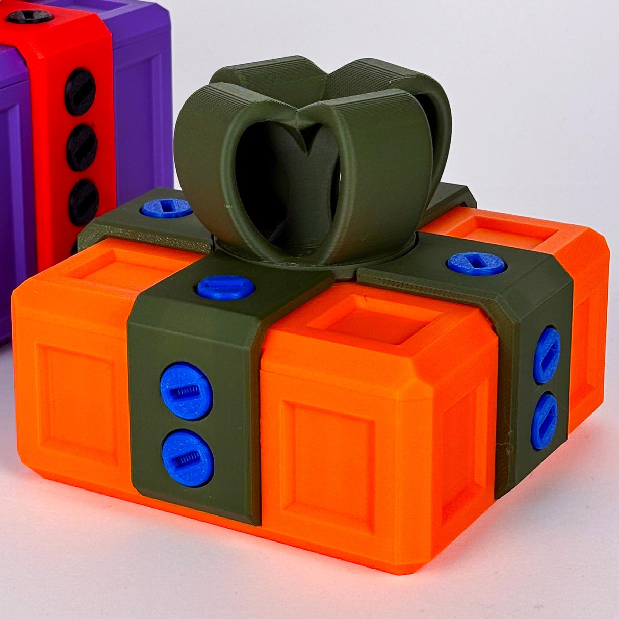 Mini Annoying Gift Box in vibrant orange and green colors, featuring playful design and locking mechanism for fun gifting.