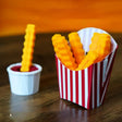 Colorful 3D-printed French fry clips in a fun striped container, perfect for sealing snack bags.