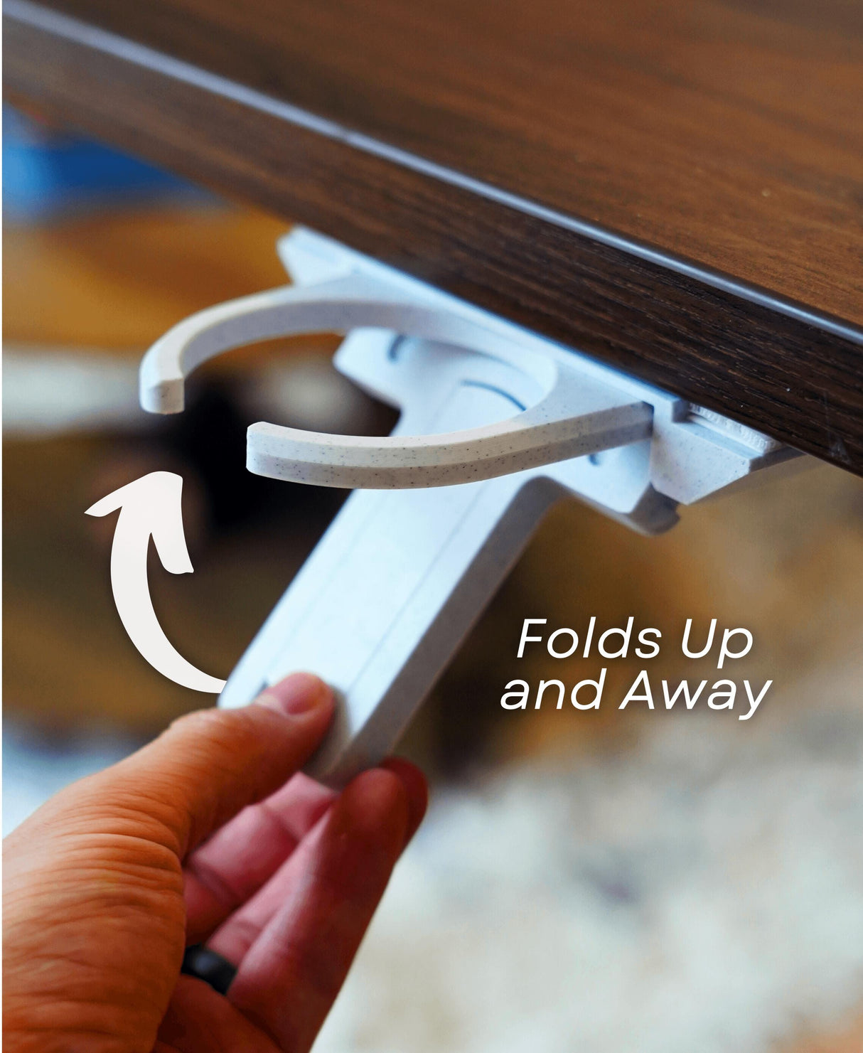 Fold-out under desk cup holder being pulled up for easy access and minimalist storage in workspace.