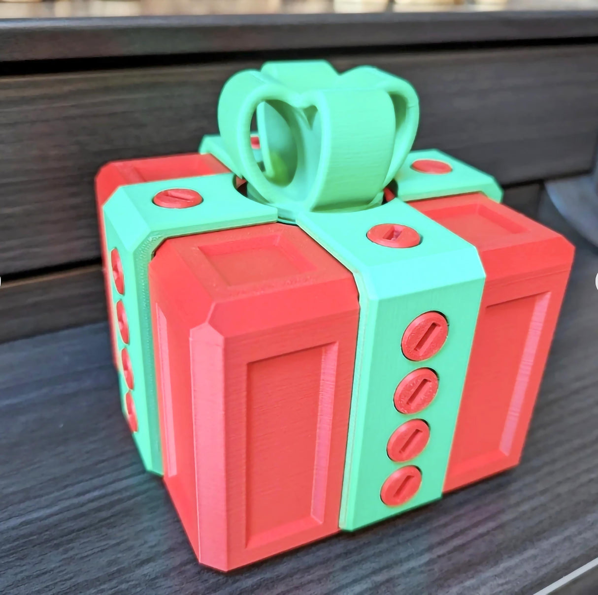 Colorful mini annoying gift box designed for fun challenges and pranks, featuring a red and green 3D printed design.