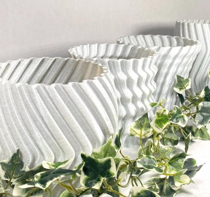 Modern zig zag planter covers in white with trailing green ivy for stylish indoor decor.