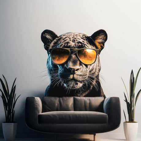 Black panther wall decal with sunglasses on a modern wall behind a stylish couch and indoor plants.