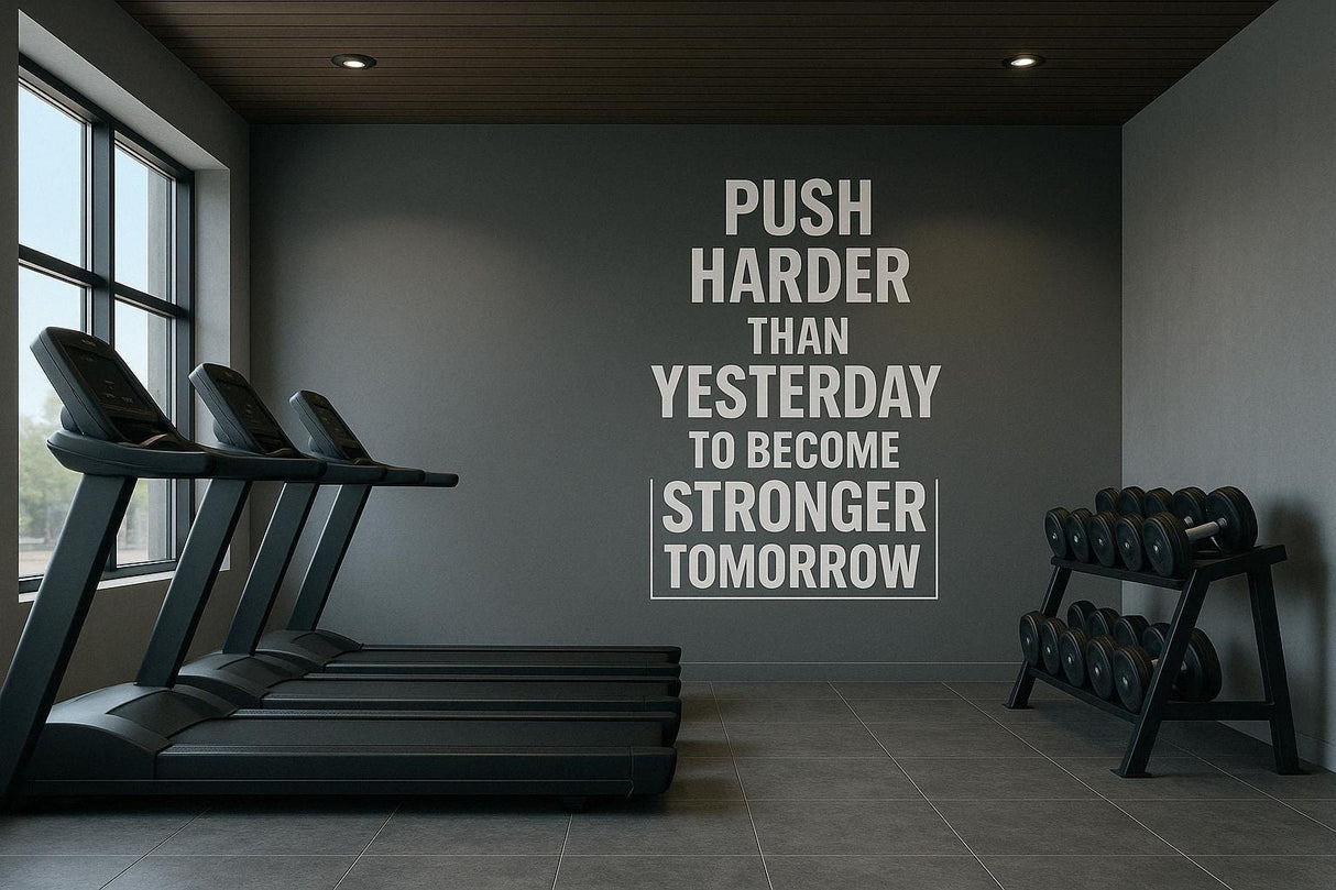 Gym interior featuring a motivational wall decal: 'Push Harder Than Yesterday to Become Stronger Tomorrow.'