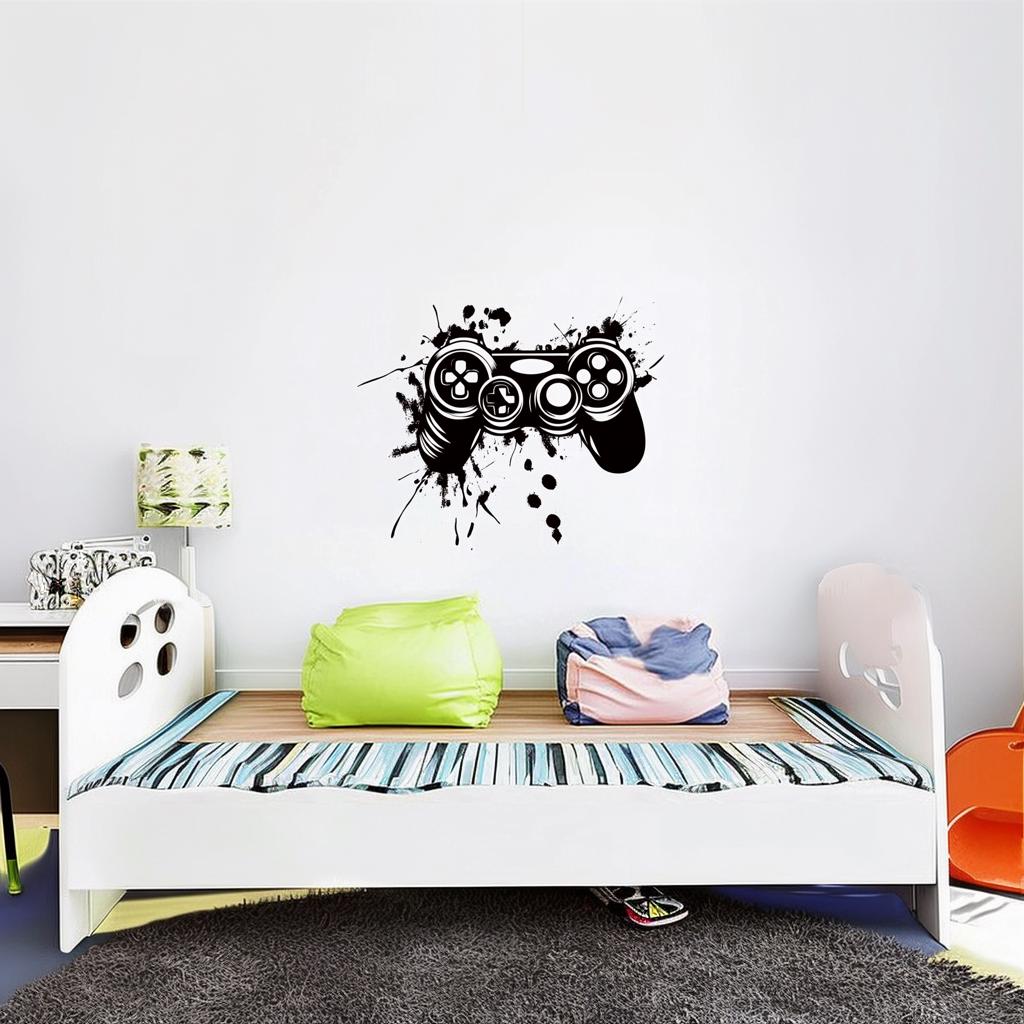 Gamer wall decal of a black video game controller with splatter design above a colorful bed in a modern kids' room.