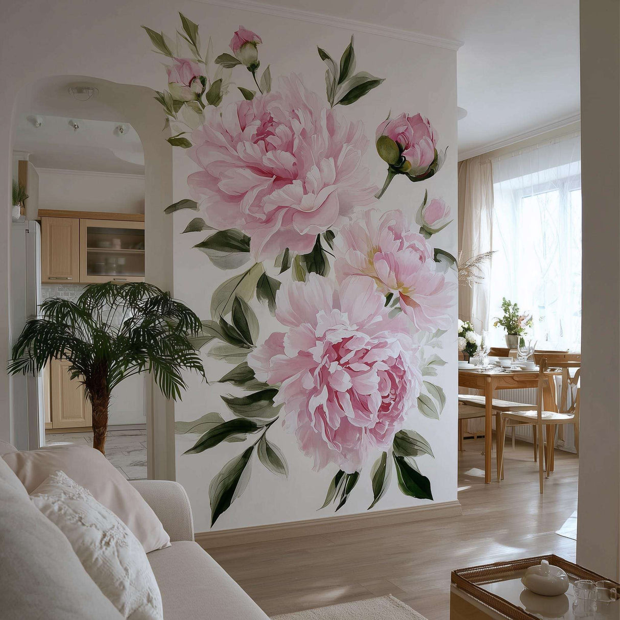 A bright, elegant living space with a large wall mural featuring soft pink watercolor peonies and green leaves. The floral design fills an accent wall between a cozy sitting area and a natural wood dining space, adding romantic charm and vibrancy.