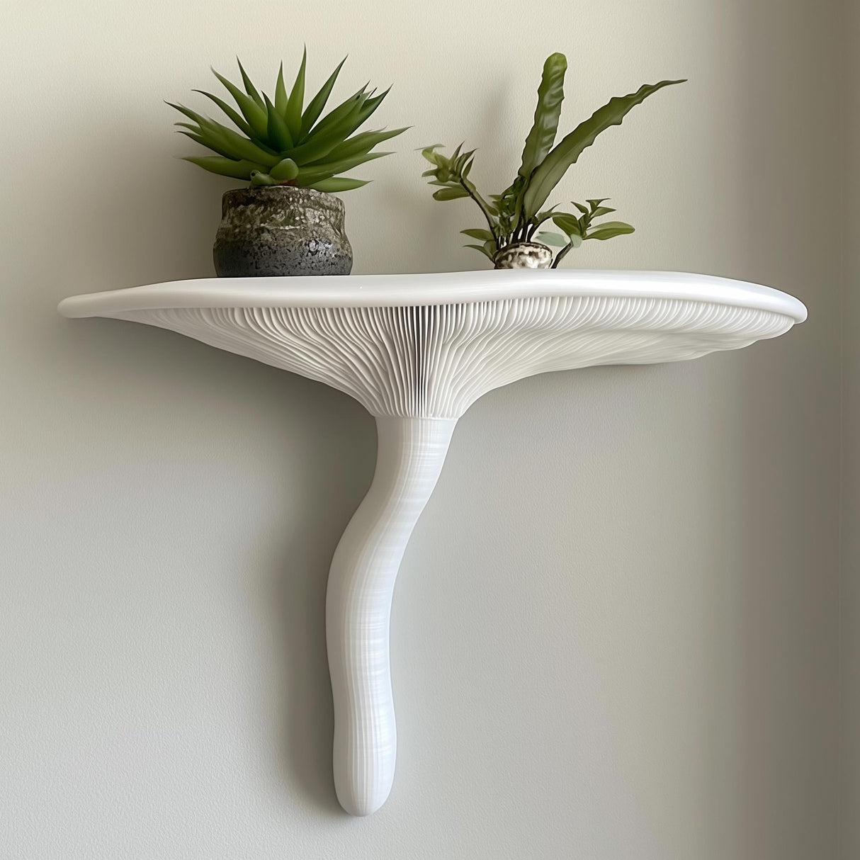 "White 3D printed wall shelf in the shape of an Artist’s Conk mushroom, styled with potted plants and mounted on a light wall."