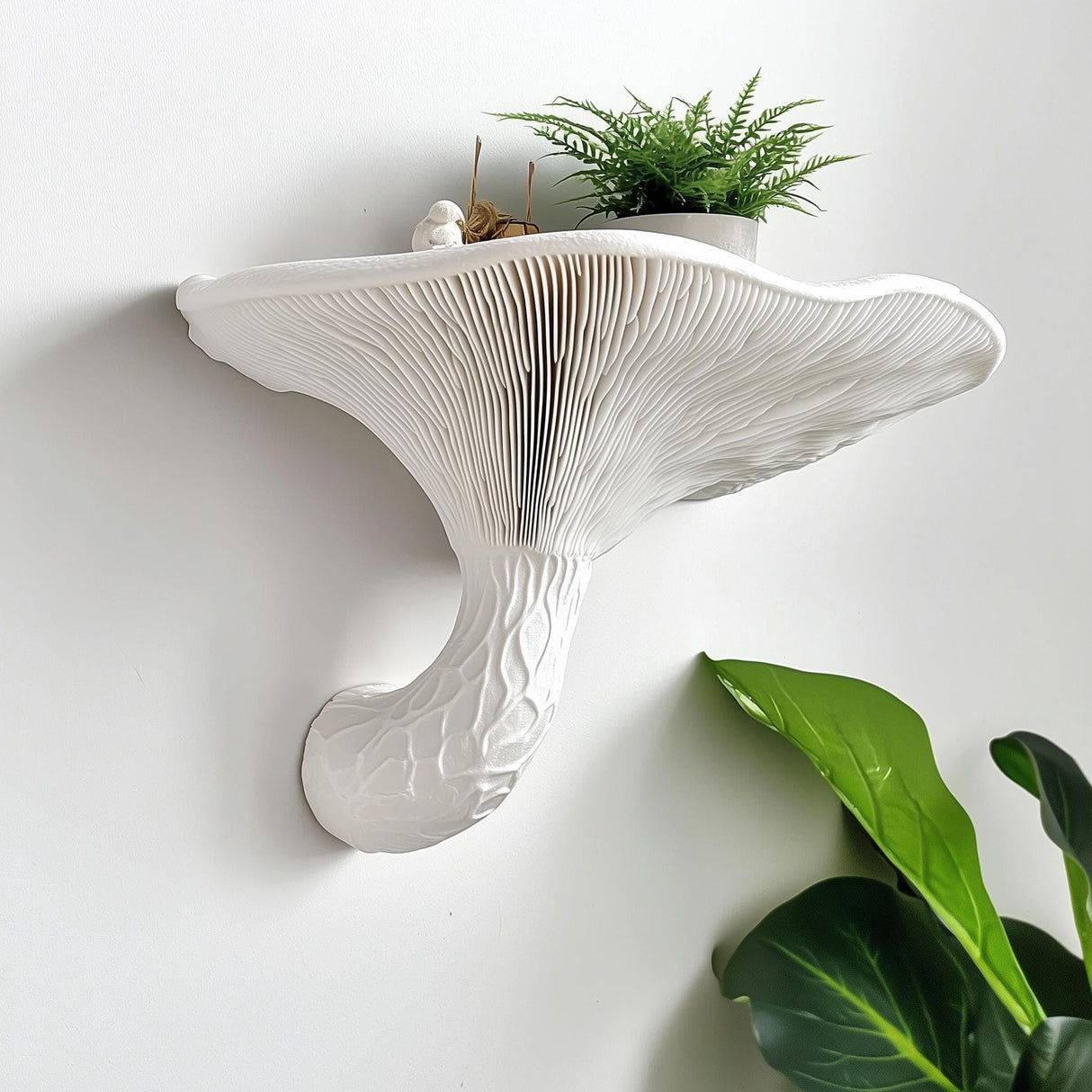 White 3D printed wall shelf inspired by honey mushroom with textured gills and curved stem, holding a small potted plant, mounted on a white wall.