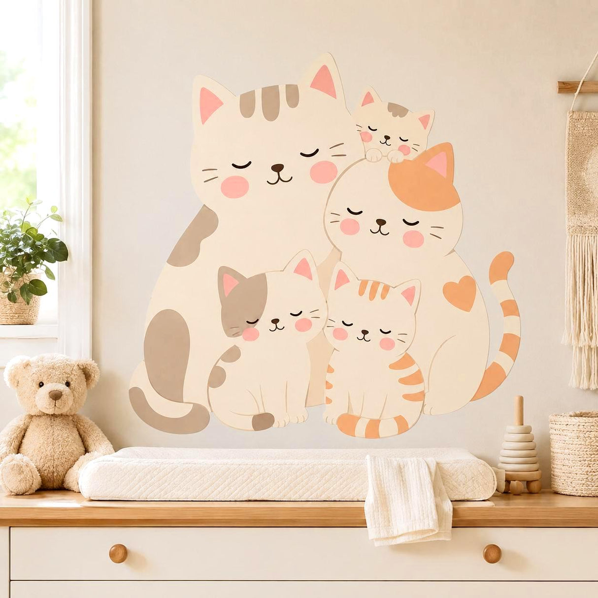 Five cuddling cartoon cats in cream, beige, and peach tones with closed eyes, pink cheeks, striped details, and curled tails on a white background.