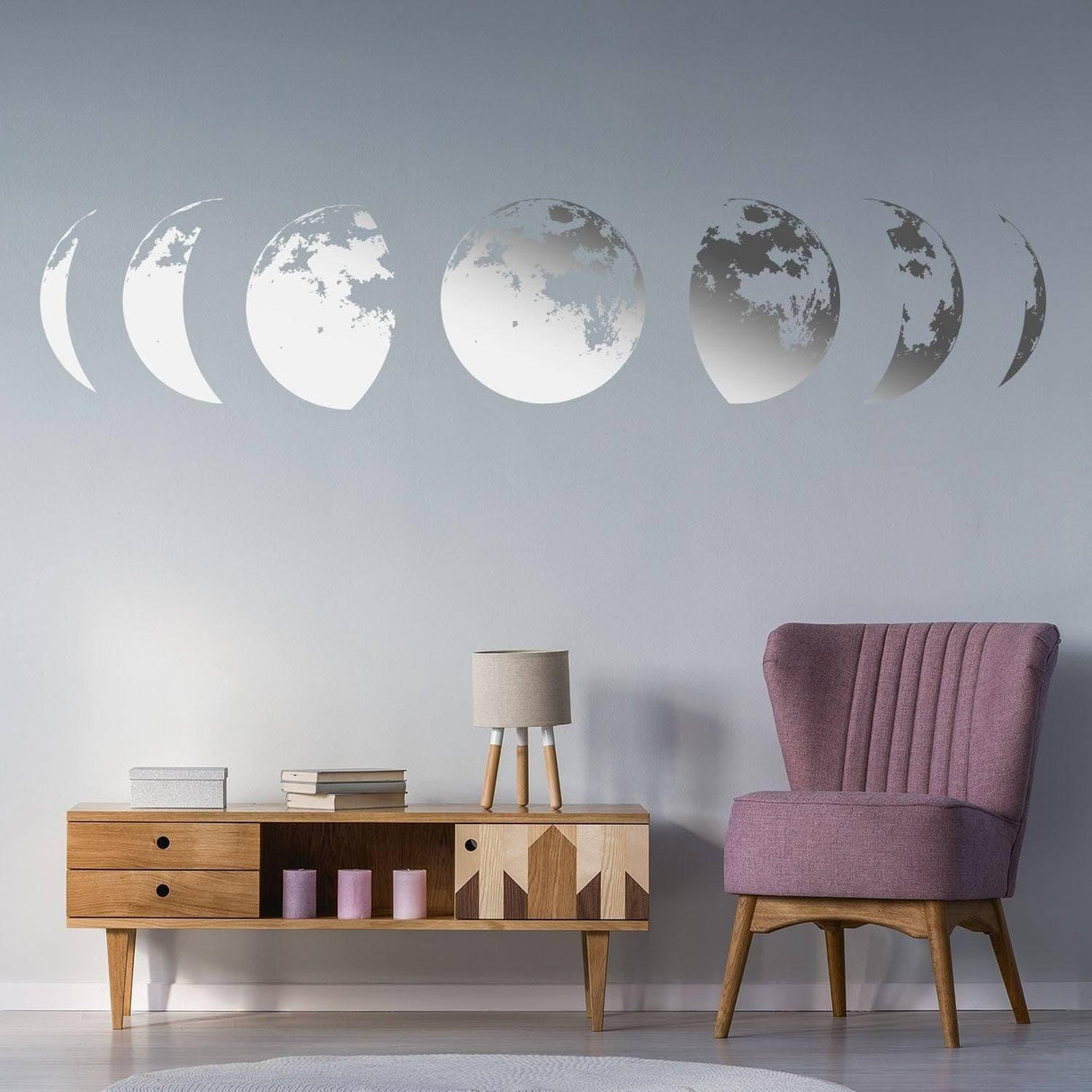 Moon phases wall decal in a modern living room decor, featuring stylish pink chair and wooden furniture.