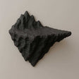 Geometric 3D printed mountain wall shelf in matte black, resembling a jagged rock peak for adventurous decor.