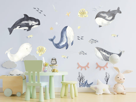 Ocean themed wall stickers featuring whales and fish in a playful child's bedroom decor.